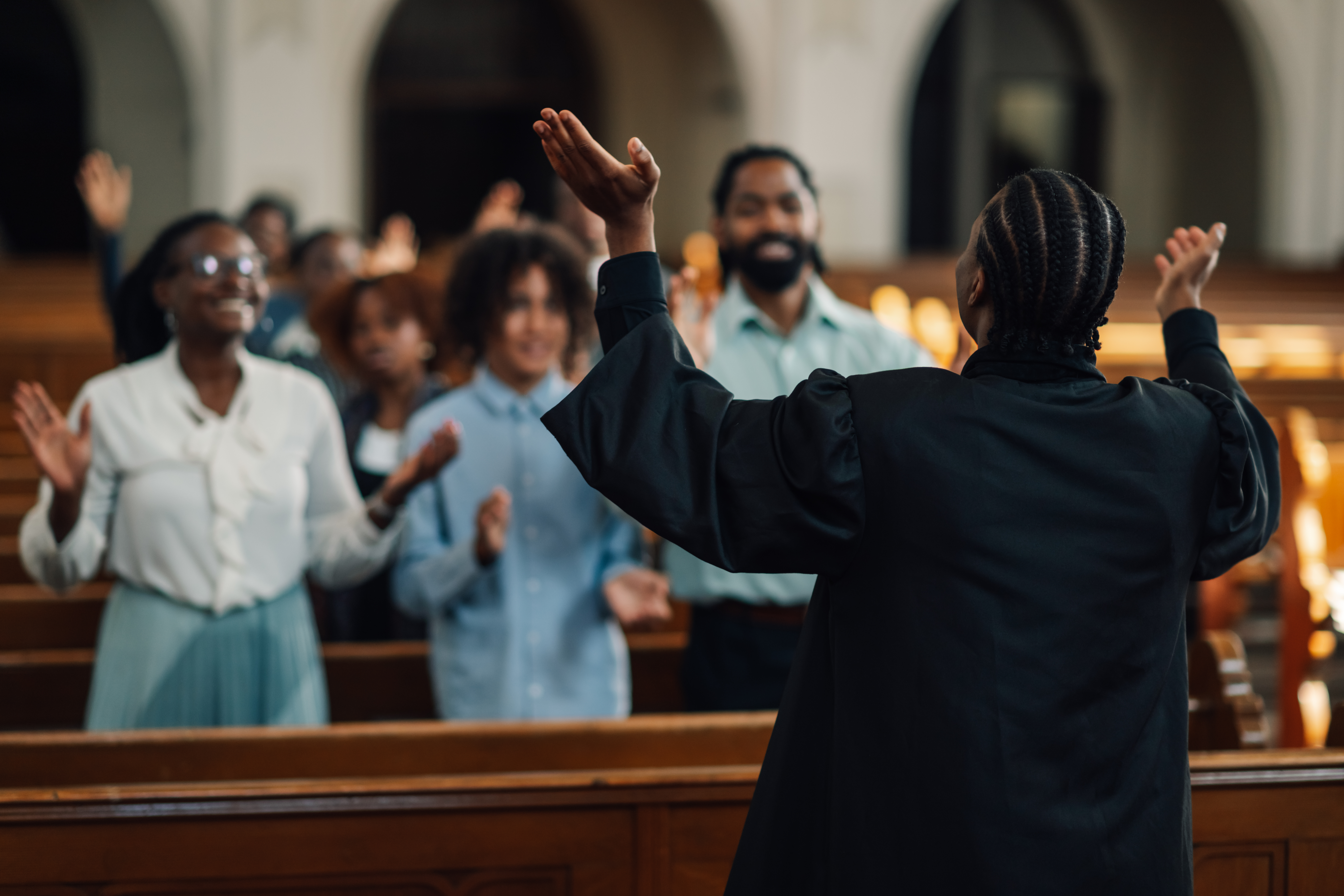 Preacher leading congregation in prayer inside church sanctuary.